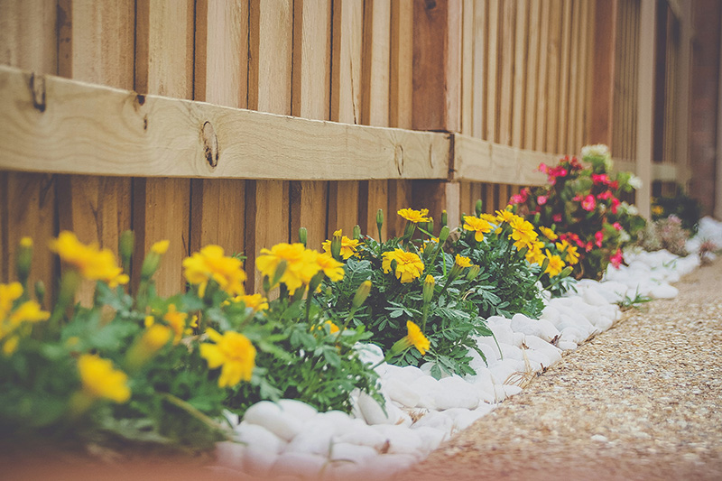 Well kept backyard with wooden fence and flower bed at the base.