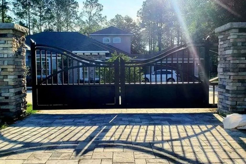 Large metal gate at the entrance of a driveway.